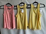 three women ' s tank tops hanging on a hanger in front of a white sheet
