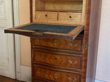 a small desk with a drawer on it in the corner of a room