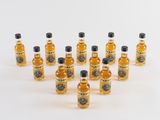 plusieurs petites bouteilles de whisky posées sur une surface blanche