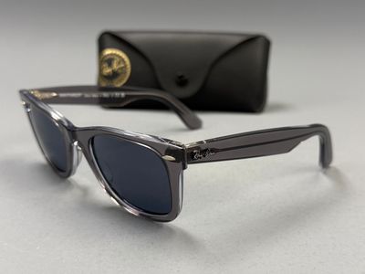 une paire de lunettes de soleil posée sur une table, à côté d'un étui