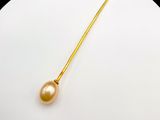 a white plate with a gold colored pearl on it