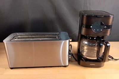 une cafetière et un grille-pain posés sur une table