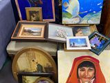 de nombreuses photos et peintures posées sur une table dans une pièce