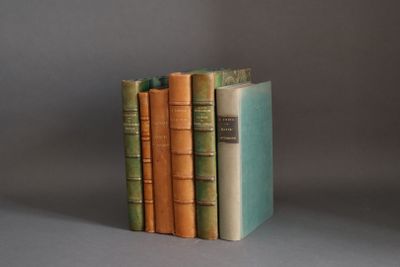 three books are stacked on top of each other on a gray surface