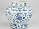 blue and white vase with flowers and vines on a gray background