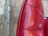 a red scooter that is parked on the sidewalk
