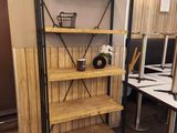 a wooden shelf with a basket on it in the corner of a room