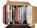 a cardboard box full of books on a white background