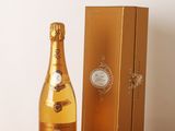 une image représentant une bouteille de champagne posée à côté d'un coffret doré