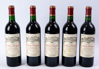quatre bouteilles de vin sont alignées sur une surface blanche