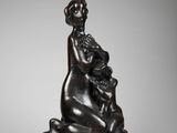 une statue en bronze d'une femme tenant un enfant dans ses bras