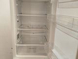 a white refrigerator with its door open in a room