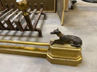 une statue représentant un chien assis sur un banc à côté d'un lit