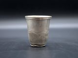 a silver cup sitting on a table with a black background