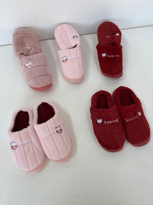 quatre paires de chaussons sont alignées sur une surface blanche