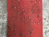 un gros plan d'un morceau de métal rouge posé sur une surface en béton