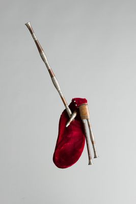 un sac rouge auquel est accrochée une paire d'aiguilles à tricoter