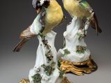 deux figurines d'oiseaux posées sur un socle en or