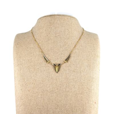 un collier en or orné d'une dent de requin autour du cou d'un mannequin