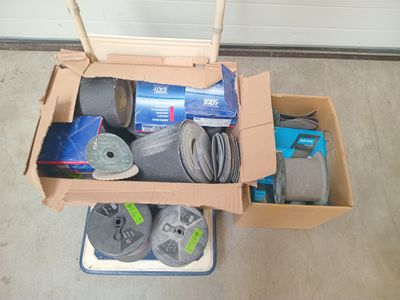 une boîte posée par terre, contenant de nombreux outils