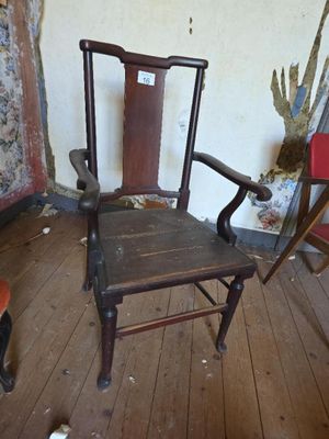 a wooden chair sitting in a room with a wallpapered wall