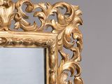 a mirror with a gold frame on the wall