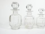 three glass bottles sitting next to each other on a white surface