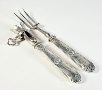 deux fourchettes et un couteau sur une table blanche