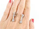 an image of a woman ' s hand with a pair of diamond earrings on it