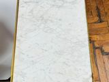 an image of a white marble table with a gold frame on it