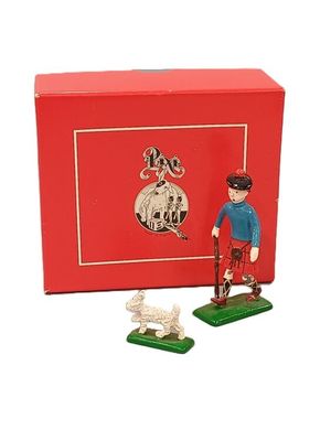 une petite figurine représentant un homme et un chien devant une boîte rouge