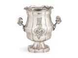 un vase en argent posé sur une surface blanche
