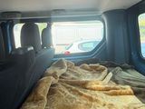 a bed in the back of a truck with a blanket on it