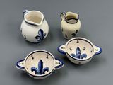 four pieces of blue and white pottery sitting on a gray surface