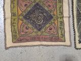 several rugs are laid out on the floor with a person standing next to them
