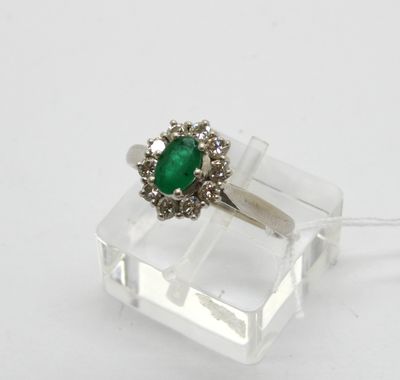un gros plan d'une bague ornée d'une pierre verte posée sur une surface transparente