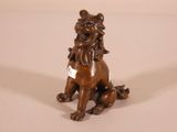 a bronze statue of a lion sitting on the ground