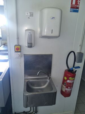 un lavabo et un extincteur dans une petite pièce
