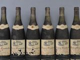 six bottles of wine are lined up on a table