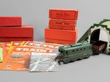 un petit train miniature posé à côté de quelques livres