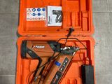 une boîte à outils orange contenant des outils, posée sur un sol carrelé