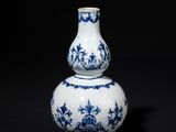 blue and white vase on a black surface with a black background