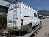 a white van that is sitting on a flatbed trailer