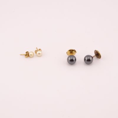 une paire de boucles d'oreilles à clous en or et perles noires