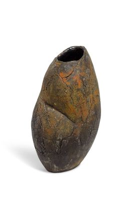 un petit vase posé sur une surface blanche