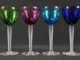 four wine glasses are lined up in a row on a table