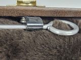 a close up of a brown bag with a metal hook