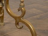 a gold candle holder sitting on a wooden floor