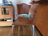 a brown chair that is sitting in front of a cabinet
