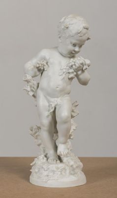 une statue blanche représentant un enfant tenant une fleur